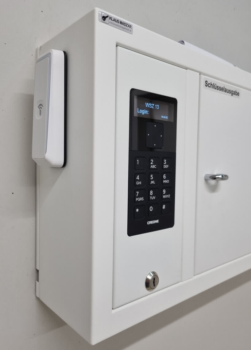 Elektronische Schlüsselausgabe mit PIN-Code-Eingabe und RFID-Lesegerät an einer weißen Wand montiert