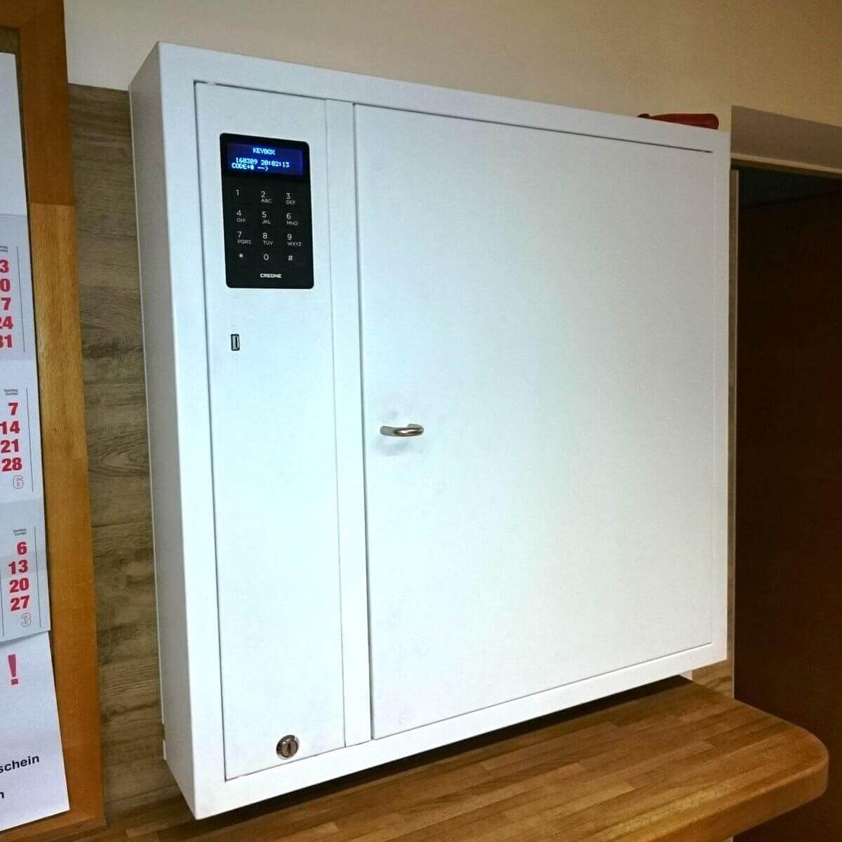 Weißer Schlüsselschrank mit digitalem Zahlencode und Display zur sicheren Schlüsselaufbewahrung an der Wand montiert