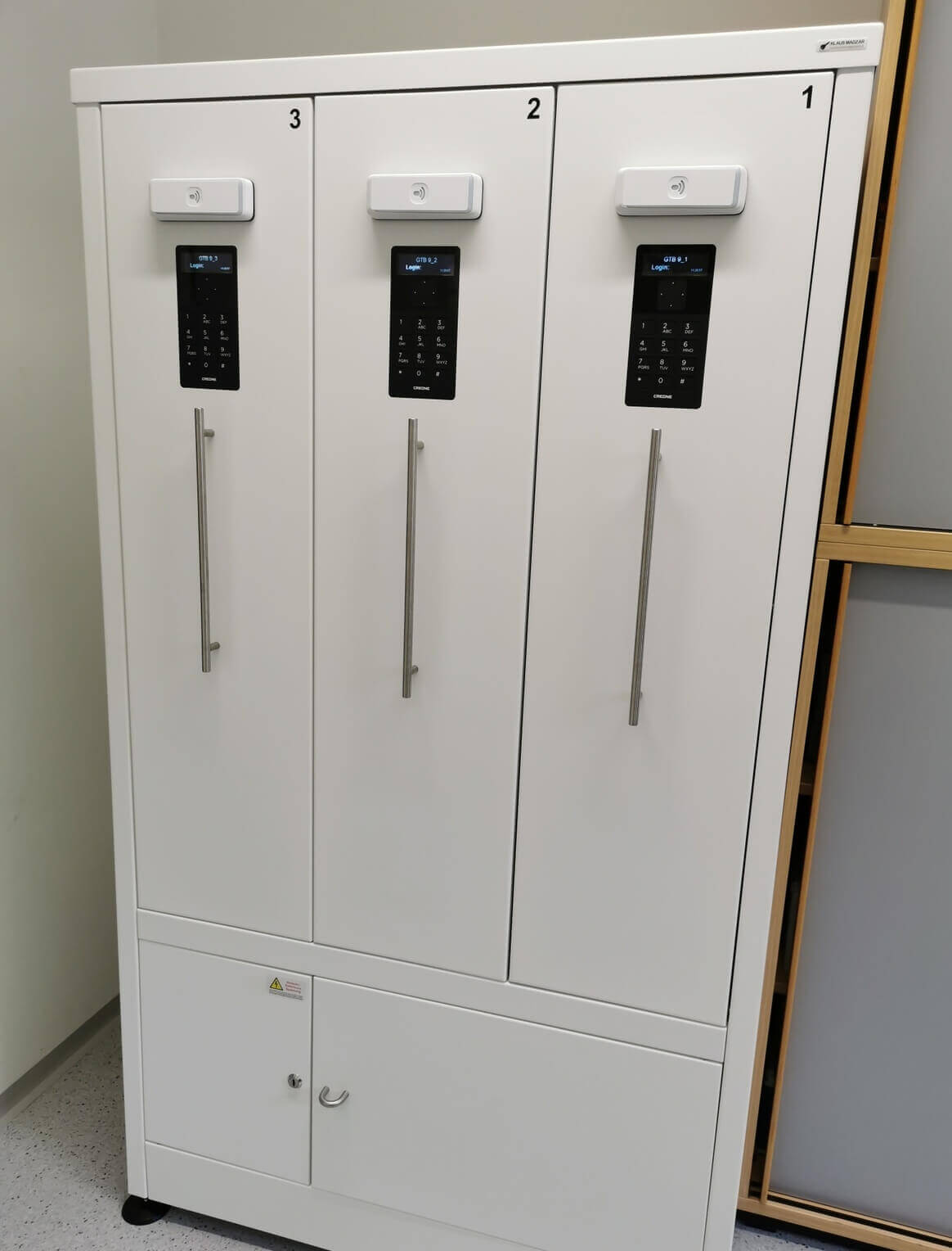 Dreifacher Spindschrank in Weiß mit elektronischen Zahlenschlössern und langen Griffen, geeignet für Büros oder Umkleideräume