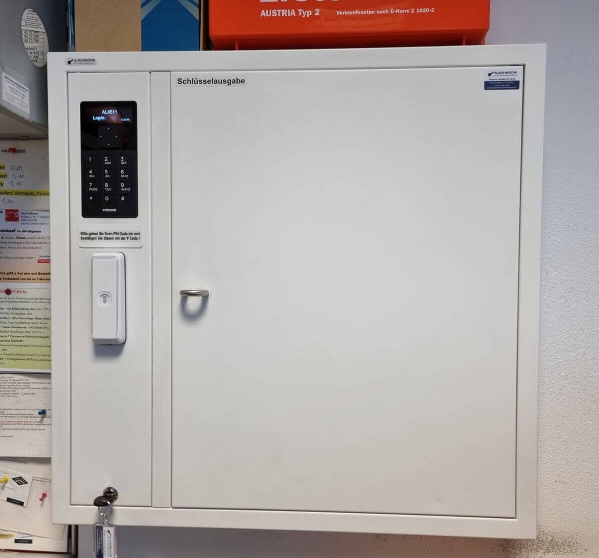 Weißer Schlüsselausgabe-Schrank mit elektronischem Zahlenfeld und RFID-Leser zur sicheren Schlüsselverwaltung an der Wand montiert
