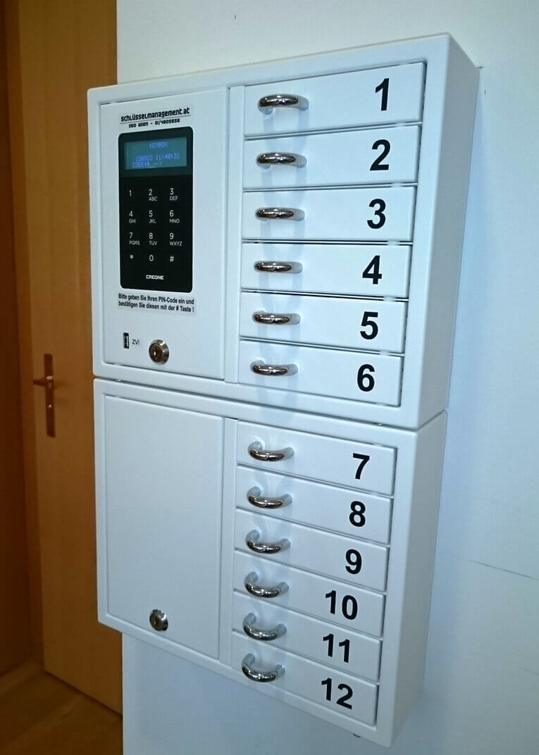 Weißer Schlüsselkasten mit 12 nummerierten Fächern und elektronischem Zahlenschloss, zur sicheren Aufbewahrung und Verwaltung von Schlüsseln.