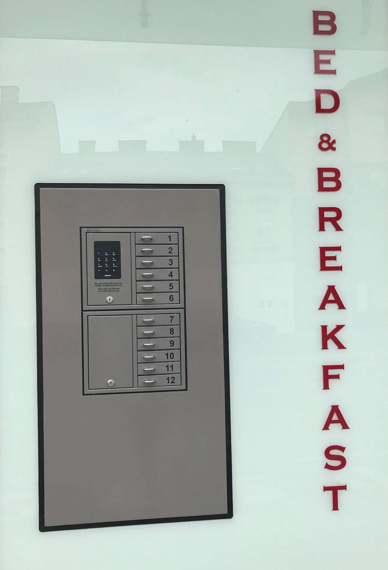 Moderner Schlüsselsafe mit elektronischem Zahlenschloss und mehreren Fächern an einer Bed & Breakfast Unterkunft