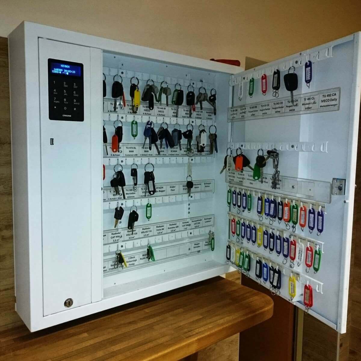 Geöffneter elektronischer Schlüsselkasten mit vielen Schlüsseln und Anhängern, sortiert und beschriftet zur übersichtlichen Schlüsselverwaltung