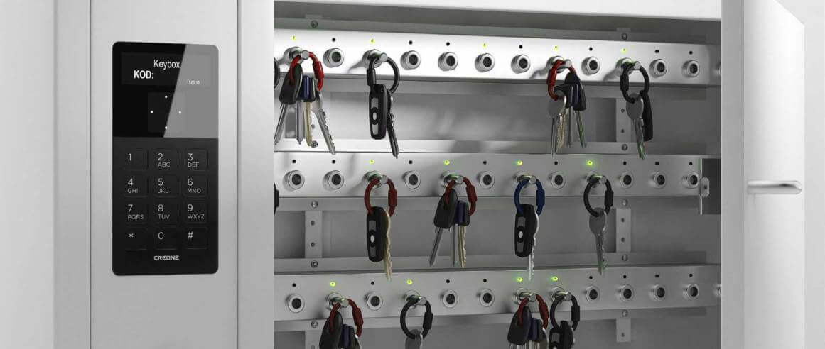 Elektronischer Schlüsselschrank mit Code-Eingabe und mehreren Schlüsseln an Haken Moderner, geöffneter Schlüsselschrank mit digitalem Bedienfeld und zahlreichen Schlüsseln an Haken