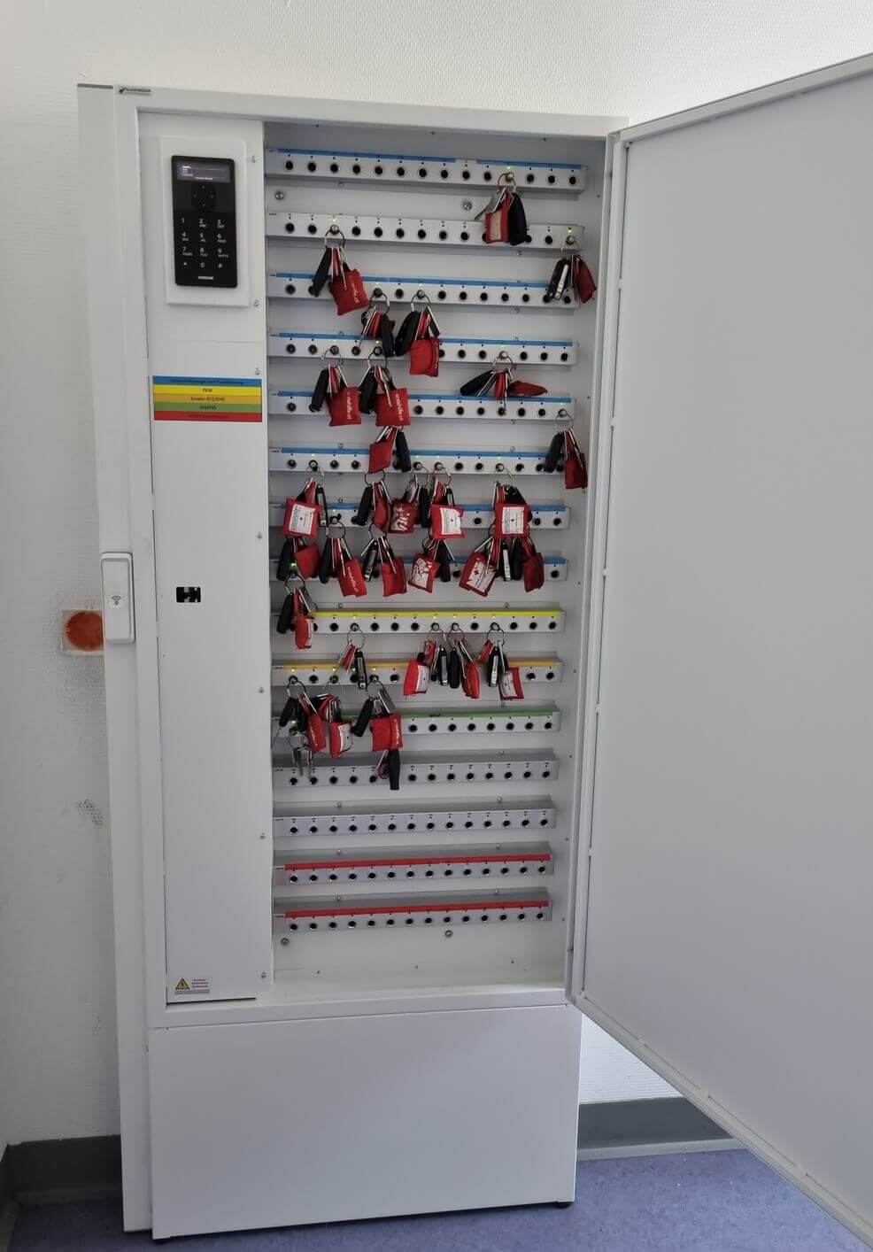 Offener, elektronischer Schlüsselschrank mit zahlreichen gelagerten Schlüsseln und digitalem Zugangssystem an der linken Seite