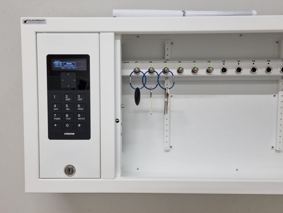 Offener elektronischer Schlüsselkasten von CREONE mit Tastatur, Display und drei an Haken hängenden Schlüsseln
